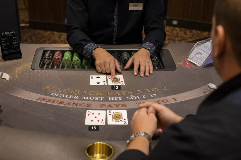 Krupier porównujący ręce z graczami przy blackjacku